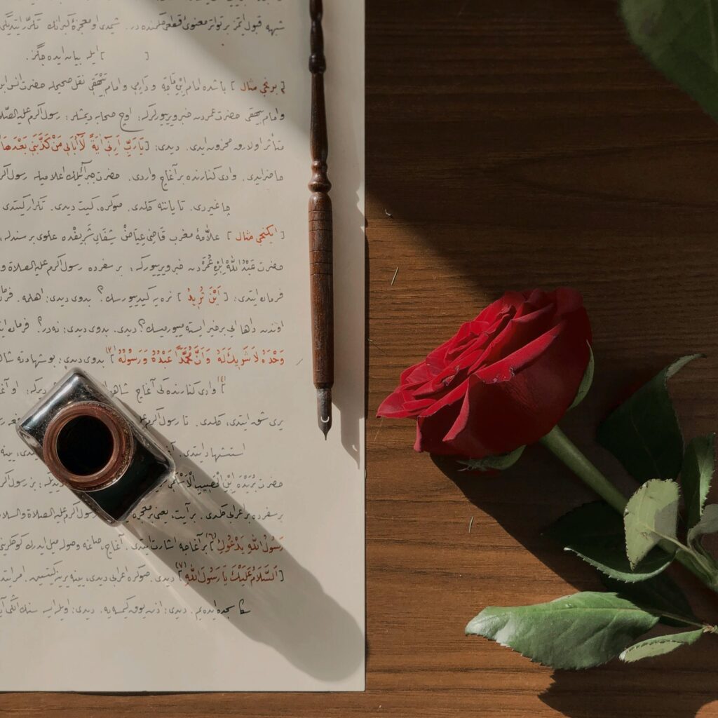 Słów-miarka Elegant calligraphy with red rose and ink pen on wooden table, perfect for artistic themes.