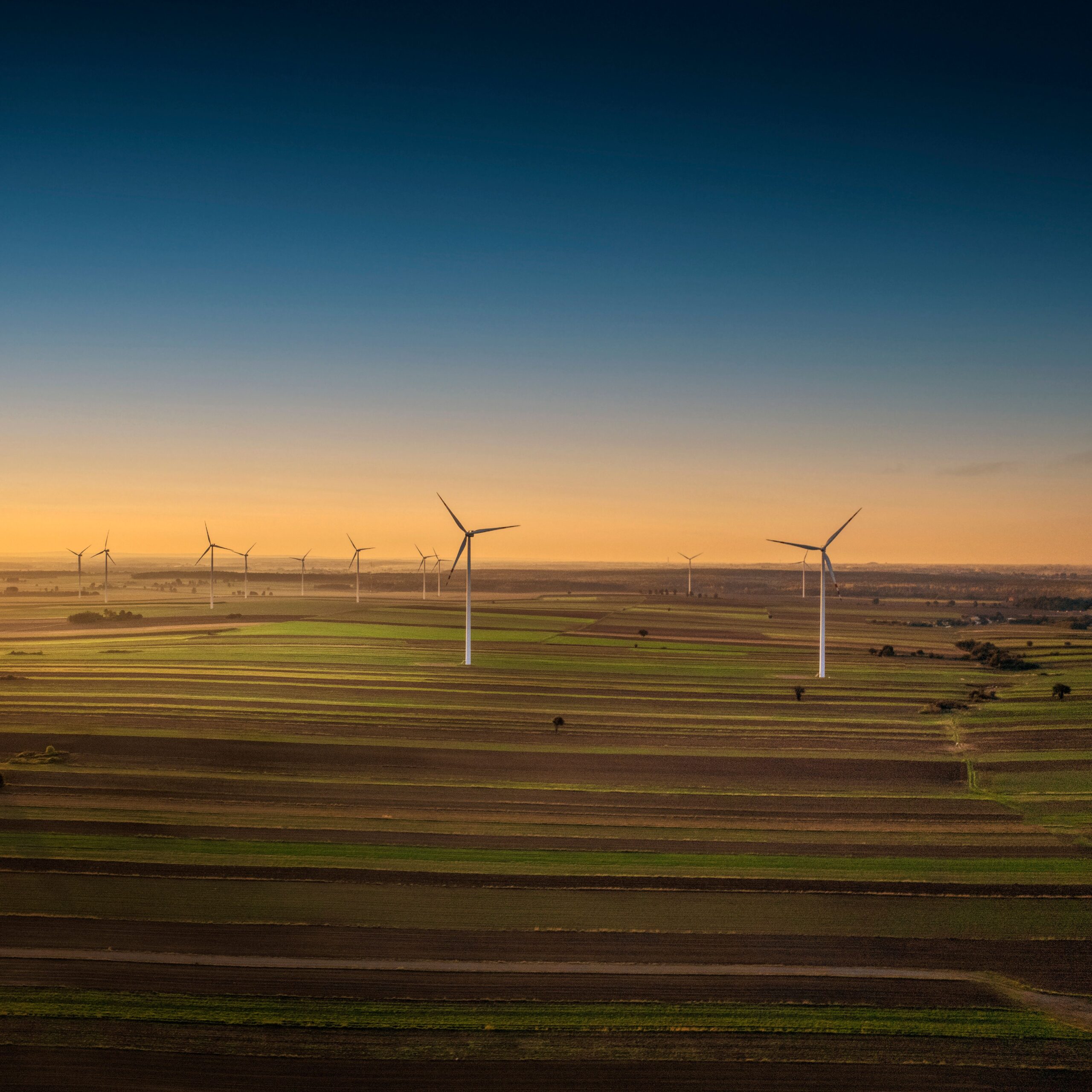 Aerial view of wind turbines in Iłża, Poland at sunset, showcasing sustainable energy in the countryside.